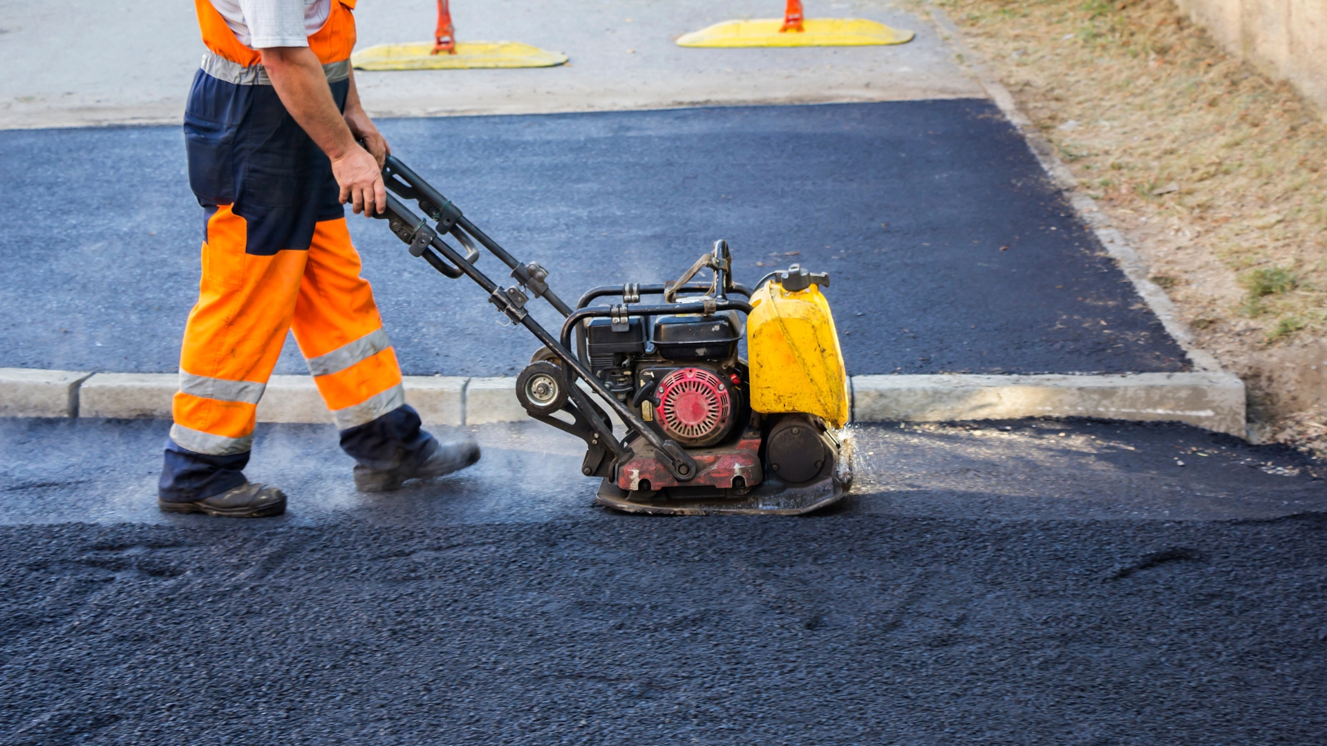 A man is using a small machine on the street