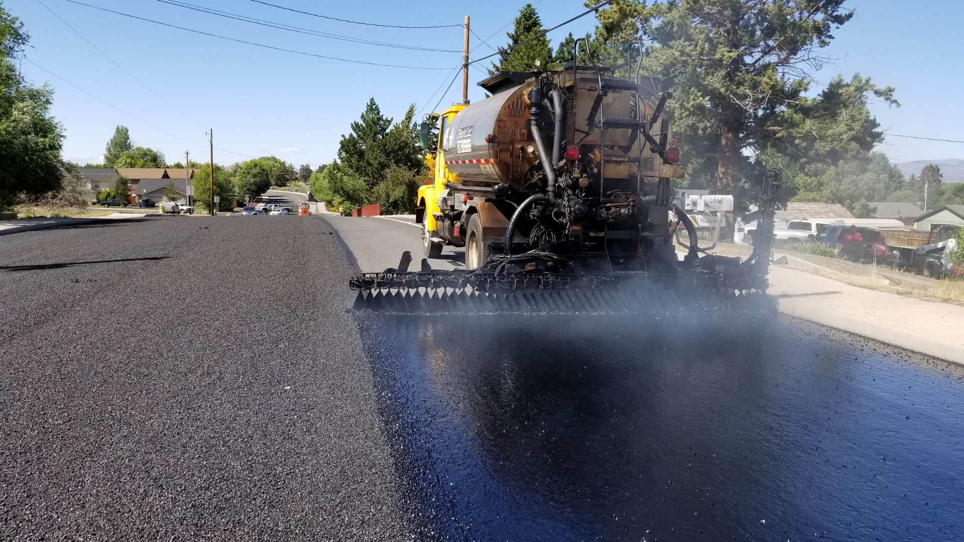 A large truck is spraying water on the street